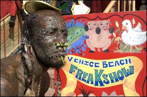 Creature, of AMC's new reality show 'Freakshow,' waits for passersby to come see the Venice Beach Freakshow on the boardwalk of Venice Beach, Calif.