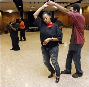 Tanisha Elliott, 33, of Fancy Footwork, dances with Rineil Rayford during an urban dance and ballroom workshop at UT's Student Union Ingman Room.