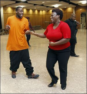 Ramar Jones dances with Ebony High during an urban dance and ballroom workshop at the University of Toledo's Student Union Ingman Room. Calling the instructions is Edwin Rhodes.