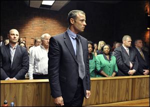 Olympian Oscar Pistorius stands following his bail hearing in Pretoria, South Africa, today. He is charged with premeditated murder.