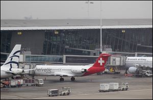 Baggage carts make their way past a Helvetic Airways aircraft at Brussels Airport where thieves stole millions' of dollars worth of diamonds from the hold of a Swiss-bound plane without firing a shot, authorities said.