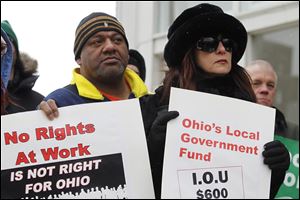 AFSCME member Mark Factor, of Ottawa, Ohio, and Theresa Allen, former Township trustee of Allen County, protest at the State of the Worker rally outside Veterans Memorial Civic & Convention Center in Lima, Ohio where Ohio Gov. John Kasich will give his State of the State address.
