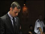  Olympic athlete Oscar Pistorius stands inside the court as a police officer looks on during his bail hearing at the magistrate court in Pretoria, South Africa, today.