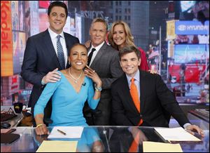Robin Roberts, left, rejoins the 'Good Morning America'  George Stephanopoulos,  (standing, from left) Josh Elliott, Sam Champion, and Lara Spencer Wednesday morning.