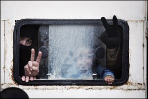 Displaced Syrian people make the victory sign inside wagon while going to Azaz camp for displaced people today, north of Aleppo province, Syria.