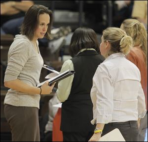 Assistant coach Ali Mann, left, speaks with head coach Jennifer Roos during a time out ealier this season. 