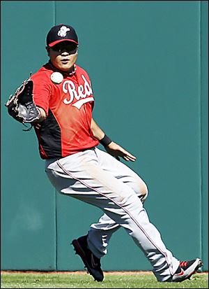 The Reds’ Shin-Soo Choo fields a hit by the Indians' Carlos Santana in the first inning.