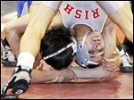 Central Catholic wrestler Nate Hagan works for a takedown against Santana Villarreal of Defiance during their Division II 126 pound district final match at the Stroh Center at Bowling Green State University. Hagan won a 4-2 decision over the opponent who beat him in sectionals a week ago.