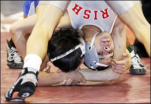 Central Catholic wrestler Nate Hagan works for a takedown against Santana Villarreal of Defiance during their Division II 126 pound district final match at the Stroh Center at Bowling Green State University. Hagan won a 4-2 decision over the opponent who beat him in sectionals a week ago.