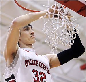 Jackson Lamb, who had 31 points, cuts down the net after Bedford defeated Saline to win a share of the Southeastern Conference Red Division title, the first league crown in school history.