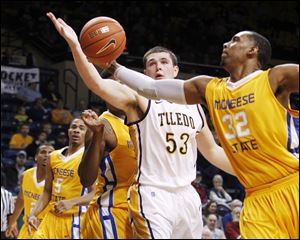Toledo's Nathan Boothe and McNeese's Desharick Guidry reach for a rebound at Savage Arena.