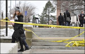 Pedestrians walk by police tape on the MIT campus today in Cambridge, Mass.,after police responded to reports of a gunman on campus that Cambridge police later said were unfounded.