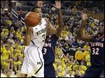  Michigan guard Trey Burke, left, passes as Illinois' Brandon Paul, center, and Nnanna Egwu defend Sunday in Ann Arbor. The Wolverines won 71-58.