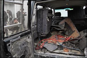Explosive materials are seen in the back of a vehicle used by an insurgent at the site where he was shot to death  in Kabul, Afghanistan, today.