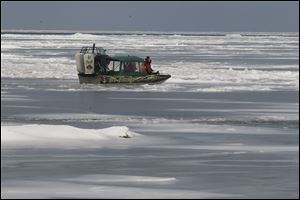 Authorities use a boat to search for a person who allegedly has fallen through the ice on Lake Erie.