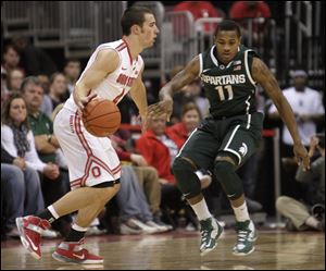 Ohio State's Aaron Craft, left, looks for an open pass as Michigan State's Keith Appling defends. Craft scored 21 points.