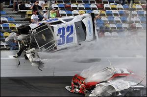 Kyle Larson (32) goes airborne and into the catch fence during a multi-car crash involving Justin Allgaier (31), Brian Scott (2) and others during the final lap of the NASCAR Nationwide Series auto race at Daytona International Speedway, Saturday.