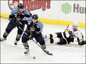 The Walleye's Patrick Knowlton, center, takes the puck away from Cincinnati's Jack MacLellan at the Huntington Center.