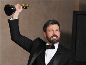 Ben Affleck poses with his award for best picture for 