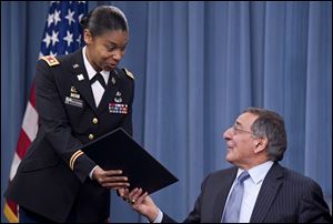 Secretary of Defense Leon Panetta hands the memorandum he has just signed, ending the 1994 ban on women serving in combat, to Army Lt. Col. Tamatha Patterson of Huntingdon, Tenn., during a news briefing at the Pentagon in Arlington, Va., in January.