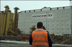 A police stands in front of a wood-processing company in Menznau, central Switzerland, today, where several people were killed in a shooting. 