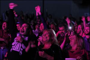 An enthusiastic crowd cheers as Bob Seger and The Silver Bullet Band perform.