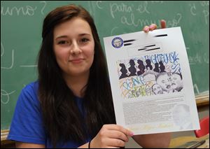 Sallie Fish, a seventh-grade student at St. Pius X School in Toledo, displays a copy of her winning entry in a statewide contest sponsored by the Ohio Civil Rights Commission.