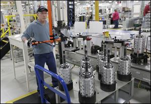 Dietz Werland works on the assembly line during a tour before an investment and jobs announcement event at the Chrysler transmission plat in Kokomo, Ind.