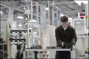 Jordan Kenyon works on the assembly line during a media tour before an investment and jobs announcement event at the Chrysler transmission plant in Kokomo, Ind.