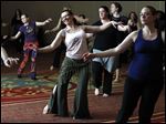  Barbara Rocci, second from left in pink sleeveless, and Kristy Windt, right, both of Ann Arbor, learn general belly dancing moves during a seminar at the Grand Plaza in Toledo.