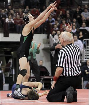 Delta’s Jake Spiess celebrates after scoring the winning takedown in overtime on Evan Ulinski of Elmore Woodmore in their Division III 106-pound championship match on Saturday.