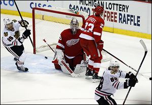 The Blackhawks’ Viktor Stalberg, left, celebrates the game-tying goal by teamate Patrick Kane, right, late in the third period. The shot beat Wings’ goalie Jimmy Howard, center, and Brian Lashoff.