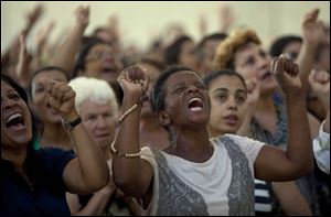 Catholics pray during a Sunday Mass in Sao Paulo.  Catholics around the world attended the first Sunday Masses since Pope Benedict’s departure.