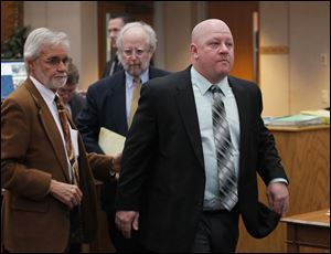 P.J. Kapfhammer, a member of the Oregon school board, right, leaves Oregon Municipal Court with attorneys Jon Richardson, left, and Scott Schwab, following his arraignment today.