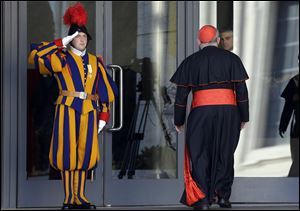 Vatican Swiss guards salute as a cardinal arrives for a meeting, at the Vatican today.