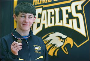 Erie Mason sophomore Logan Griffin holds the medal he won after taking the 112-pound state championship in Division 4. He won the final against Carson City Crystal’s Kenneth Dittenber 5-4 in three overtimes.