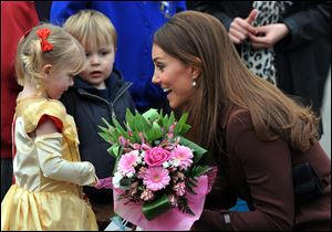 Britain's Catherine, Duchess of Cambridge receives flowers from 3-year old Isobelle Laursen, left, during her visit to Humberside Fire and Rescue Station in Grimsby, north Engalnd, Tuesday. 
