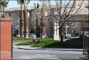 A man walks near the main gate of Glenwood Gardens in Bakersfield, Calif., where an elderly woman died after a nurse refused to perform CPR on her last week. 