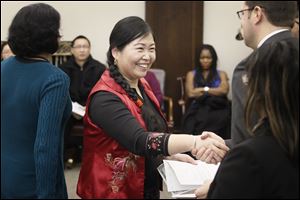 Xiang Lan Geldine of Toledo is all smiles as she receives her papers after a citizenship ceremony.