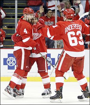 Red Wings defenseman Jakub Kindl, left, celebrates his goal with defenseman Niklas Kronwall, center, and forward Joakim Andersson, right, in the second period.