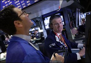 Specialist Donald Civitanova, right, works at his post on the floor of the New York Stock Exchange today. Stocks are opening higher on Wall Street after the government reported a burst of hiring last month that sent the unemployment rate to a four-year low.