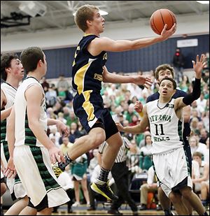 Toledo Christian's Eric Cellier, who had 13 points, goes to the basket against Ottawa Hills' A.J. King (11).