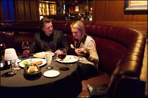 George Silva, of Toronto, left, and Maria Starrs, of Fenton, Mich., take in a meal together at the London Chop House in downtown Detroit.
