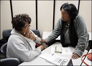 Wendy Easler, right, helps Deborah Foreman of Toledo with her taxes Friday at the Financial Opportunity Center in North Toledo.