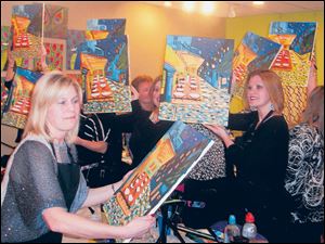 Jennifer Kranz, left, and other students hold their finished paintings.
