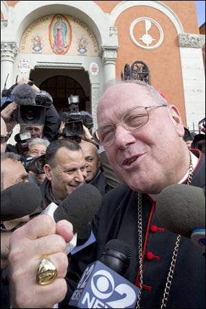A lighthearted Cardinal Timothy Dolan, archbishop of New York, greets the media as he arrives at Our Lady of Guadalupe Church to lead Mass on Sunday. 