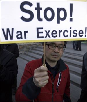 A South Korean protester holds a sign during a rally denouncing the annual joint military exercises, dubbed Key Resolve and Foal Eagle, between South Korea and the United States, near the U.S. Embassy in Seoul, South Korea,.