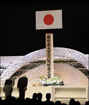 Japanese Emperor Akihito, right, and Empress Michiko bow to pay tribute to the victims of the March 11 earthquake and tsunami at the national memorial service in Tokyo.