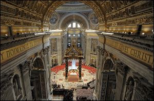Cardinals, in red, and other prelates and faithful attend a Mass for the election of a new pope celebrated by Cardinal Angelo Sodano, inside St. Peter's Basilica, at the Vatican.