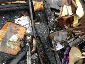 A partially burned child's photo is seen Monday in the debris of a house fire in which seven people were killed Saturday in southeastern Kentucky. Officials say two adults and five children were killed in the fire in Gray, Ky.